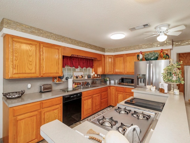 kitchen with visible vents, appliances with stainless steel finishes, light countertops, a textured ceiling, and a sink