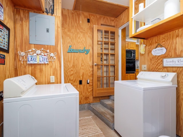 washroom with laundry area, wood walls, independent washer and dryer, and electric panel