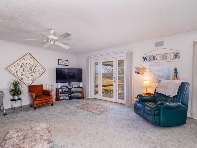 carpeted living area featuring a textured ceiling, crown molding, and french doors