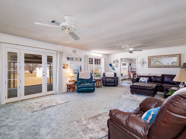 carpeted living area with french doors, visible vents, ceiling fan, and a textured ceiling