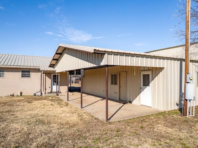 rear view of property with a patio area and metal roof