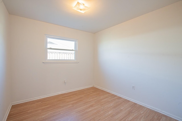 spare room featuring light wood finished floors and baseboards