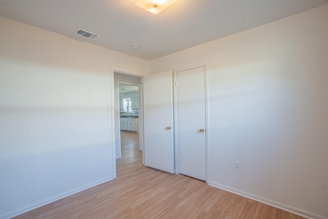 unfurnished room with light wood-type flooring, baseboards, and visible vents