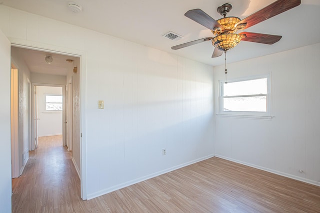 empty room with light wood-type flooring, plenty of natural light, visible vents, and ceiling fan