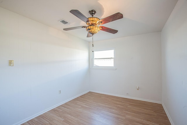 empty room featuring ceiling fan, light wood-type flooring, visible vents, and baseboards