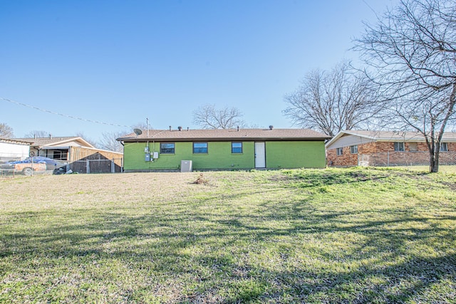 back of house featuring a yard and fence