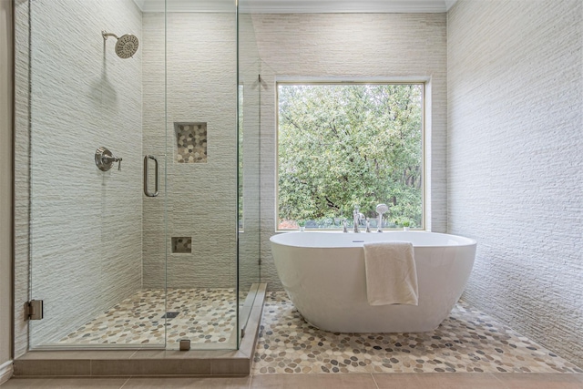 bathroom with a freestanding tub, a shower stall, and tile patterned flooring