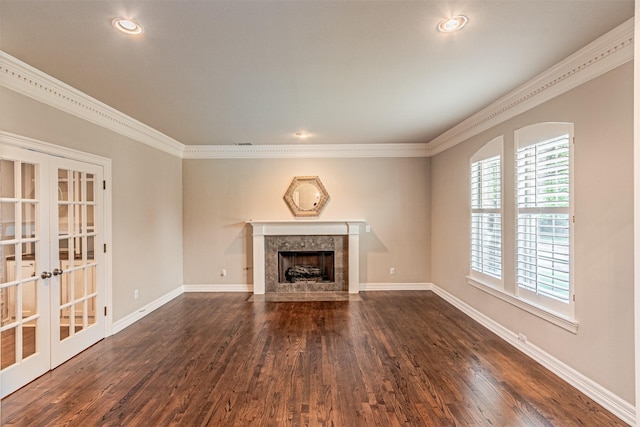 unfurnished living room with a premium fireplace, baseboards, dark wood-type flooring, and crown molding