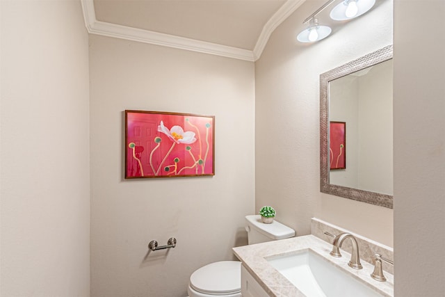 half bath featuring ornamental molding, vanity, and toilet