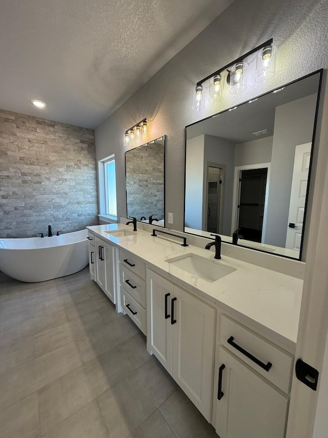 full bath featuring tile walls, a sink, a textured ceiling, and a freestanding bath