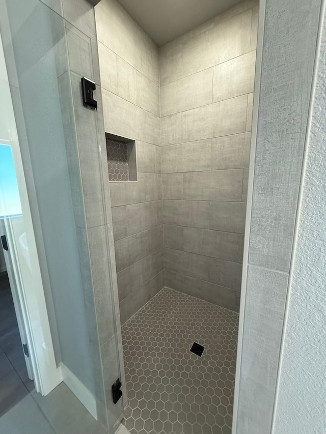 full bathroom featuring tile patterned flooring and a shower stall