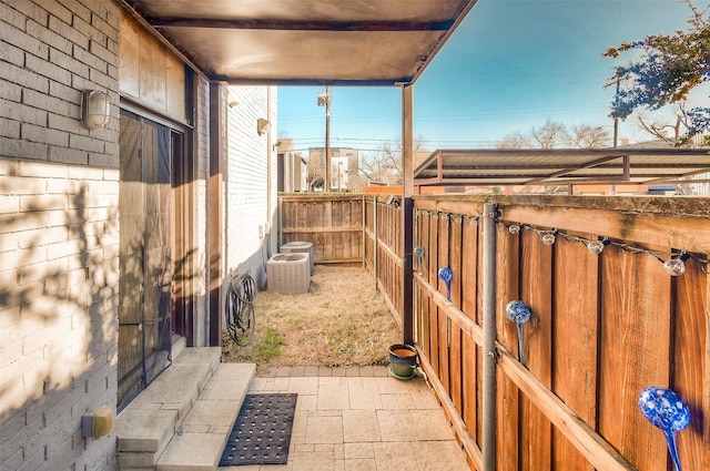 view of patio / terrace featuring central AC unit and fence