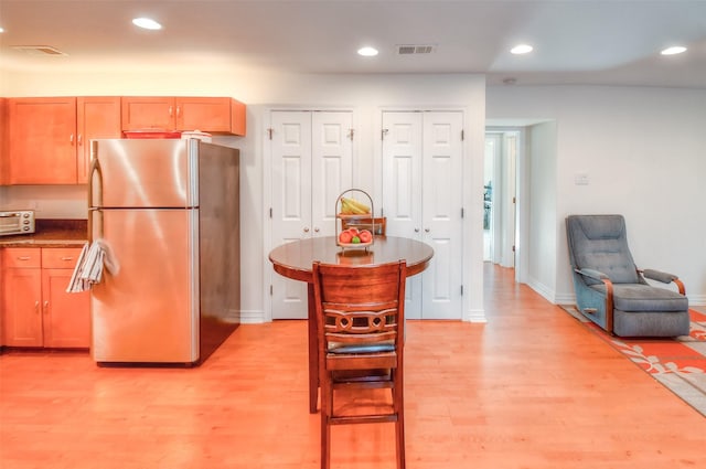 kitchen featuring light wood-style floors, freestanding refrigerator, visible vents, and recessed lighting