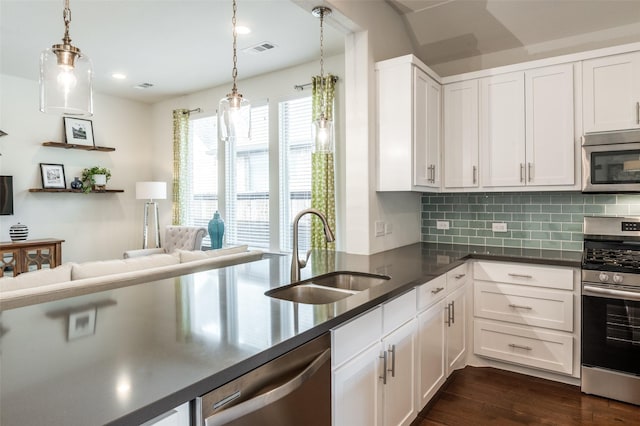 kitchen featuring visible vents, dark wood finished floors, stainless steel appliances, white cabinetry, and a sink