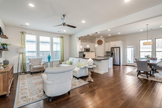 living room featuring baseboards, dark wood-style flooring, and recessed lighting