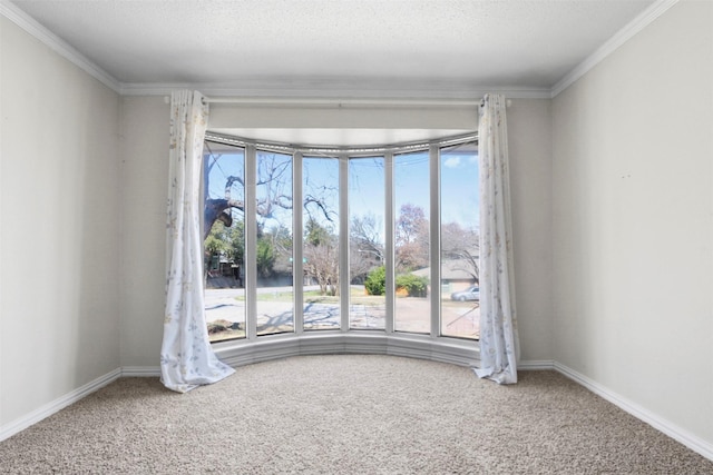 unfurnished room featuring baseboards, a textured ceiling, carpet, and crown molding