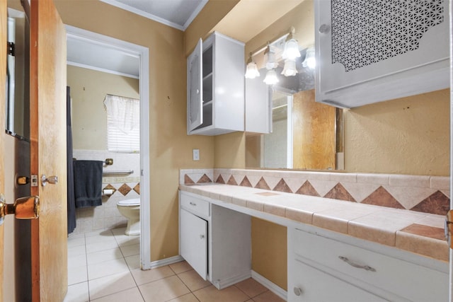 bathroom featuring toilet, vanity, crown molding, and tile patterned floors