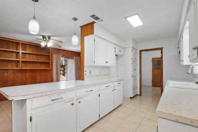 kitchen featuring light tile patterned floors, light countertops, a sink, and visible vents