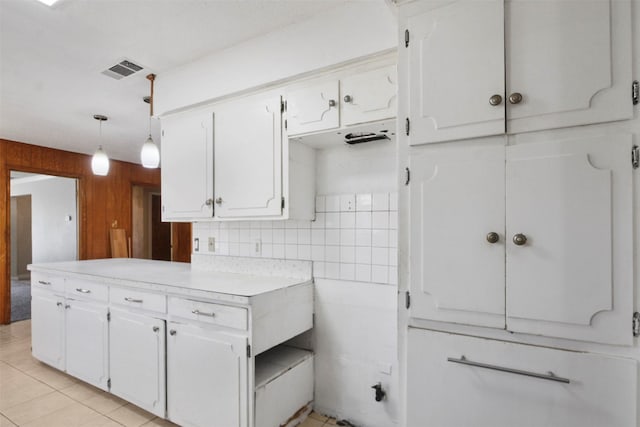 kitchen featuring light tile patterned floors, visible vents, white cabinets, light countertops, and backsplash