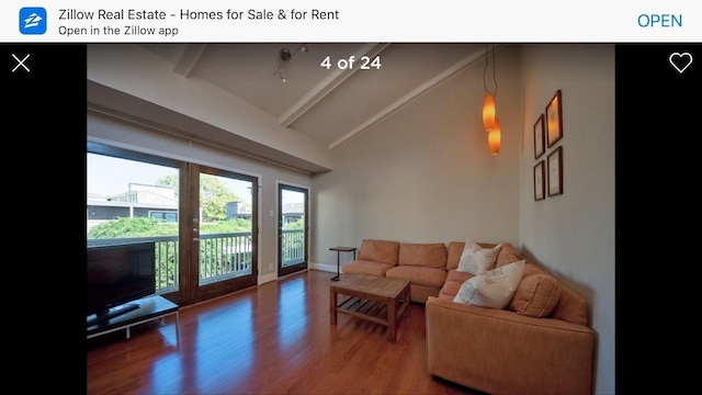 living room with lofted ceiling with beams, baseboards, and wood finished floors