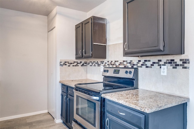 kitchen featuring tasteful backsplash, blue cabinets, light wood-style floors, and stainless steel electric stove