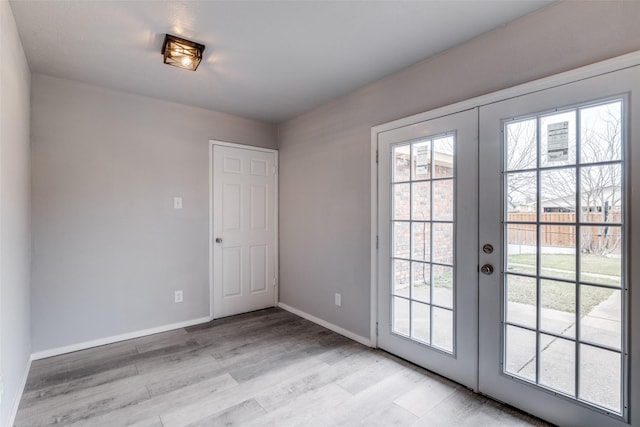 doorway to outside with french doors, baseboards, and light wood finished floors