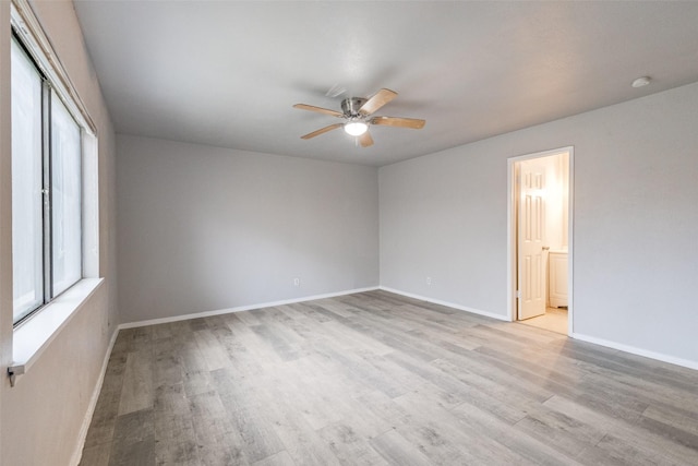 spare room featuring baseboards, ceiling fan, and light wood-style floors