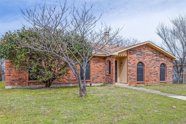 view of front of property featuring brick siding and a front lawn