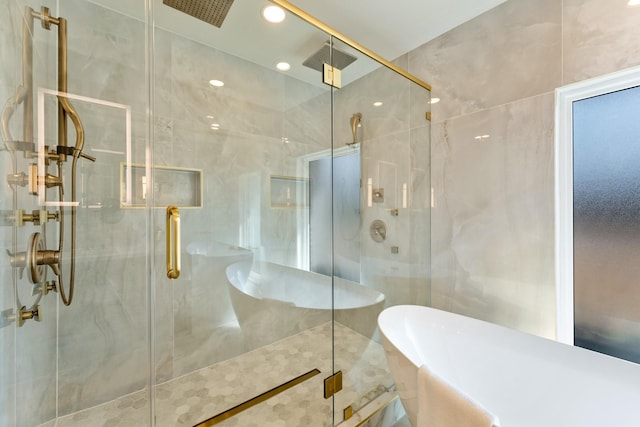 full bathroom featuring tile walls, recessed lighting, visible vents, a stall shower, and a freestanding tub