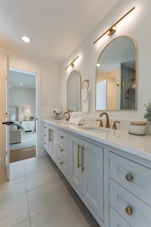 bathroom featuring double vanity, tile patterned flooring, connected bathroom, and a sink