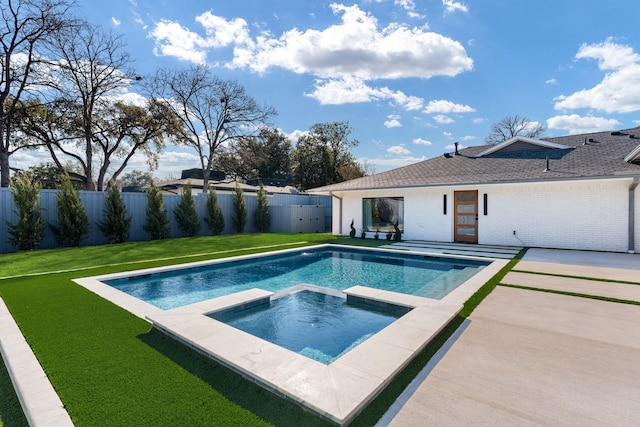 view of swimming pool with a patio, a lawn, a fenced backyard, and a pool with connected hot tub