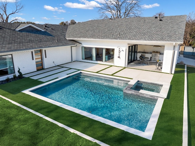 rear view of house featuring brick siding, a yard, a shingled roof, a pool with connected hot tub, and a patio area