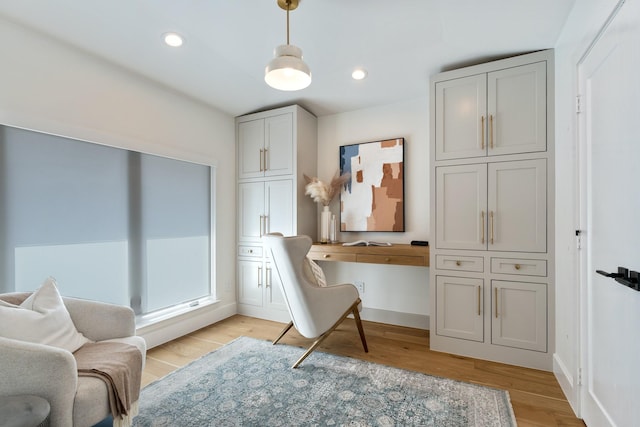 office with light wood-type flooring, baseboards, built in desk, and recessed lighting