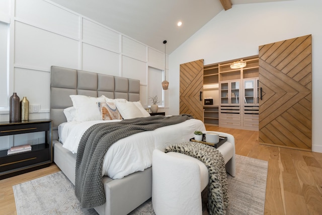 bedroom featuring light wood-style flooring, high vaulted ceiling, beamed ceiling, and recessed lighting