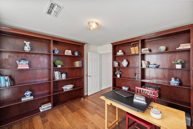 office featuring visible vents, baseboards, and wood finished floors