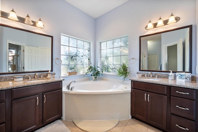 full bath featuring a bath, two vanities, and a sink