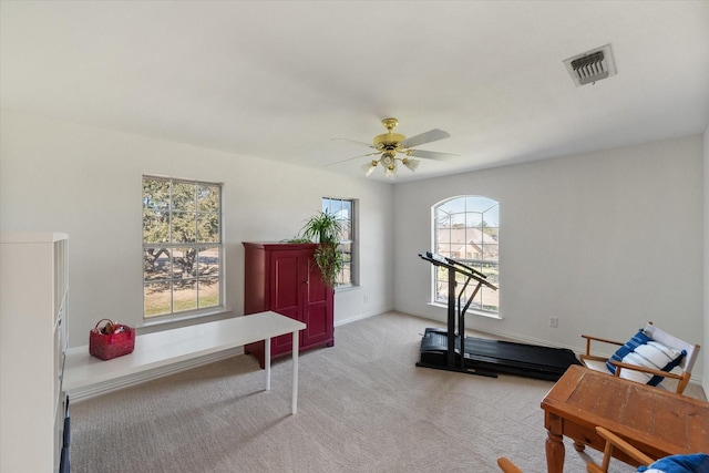 workout room featuring visible vents, light colored carpet, baseboards, and a ceiling fan