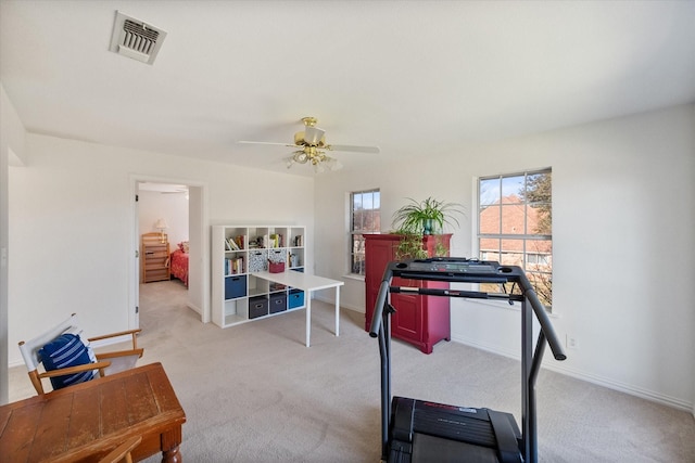 exercise room featuring ceiling fan, light colored carpet, visible vents, and baseboards