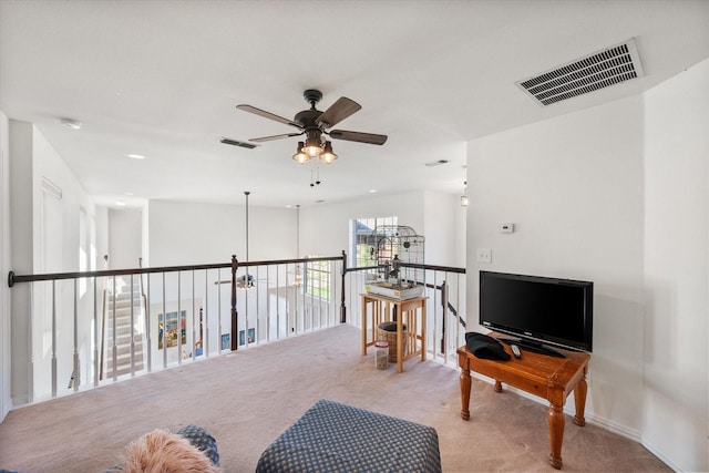 sitting room featuring visible vents, an upstairs landing, carpet, and ceiling fan