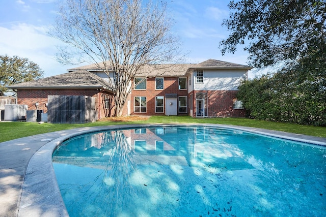 outdoor pool featuring a lawn and fence