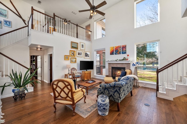 living room featuring stairway, hardwood / wood-style floors, and a tile fireplace