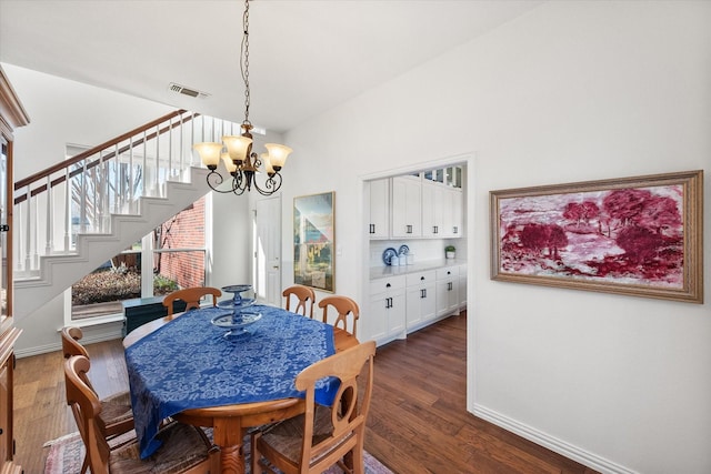 dining space featuring visible vents, dark wood-style floors, stairway, baseboards, and a chandelier