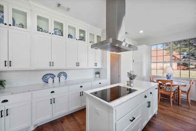 kitchen featuring visible vents, island exhaust hood, dark wood-type flooring, white cabinets, and black electric cooktop