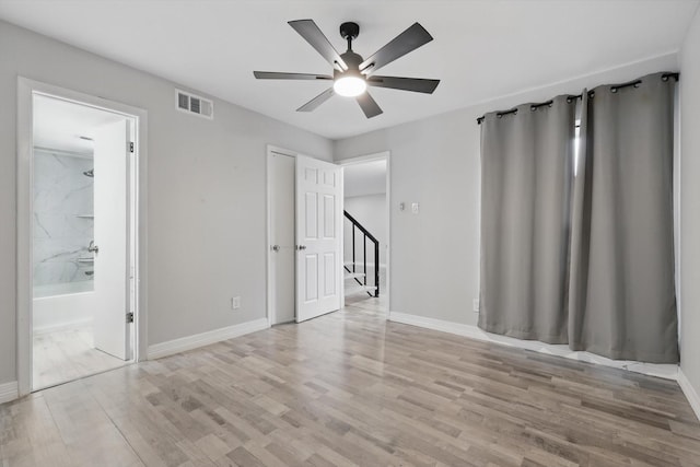 spare room with baseboards, visible vents, and light wood finished floors