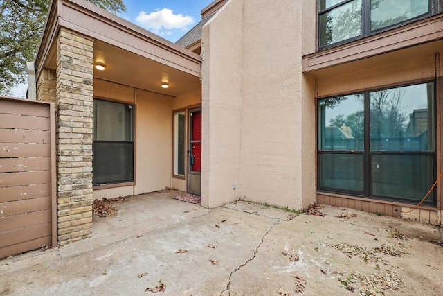 entrance to property featuring a patio area and stucco siding