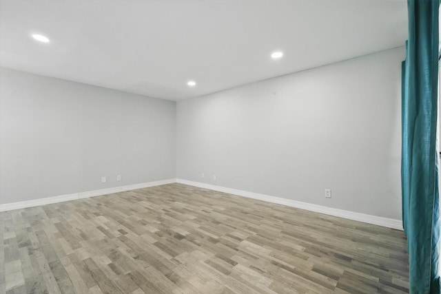 spare room with recessed lighting, light wood-style flooring, and baseboards