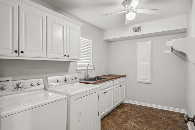 clothes washing area with cabinet space, visible vents, baseboards, washing machine and dryer, and a sink