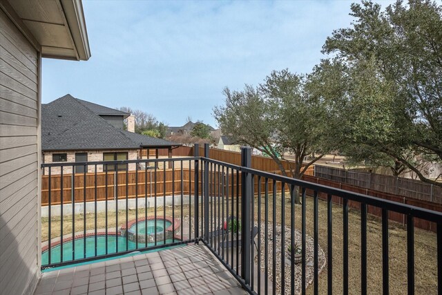 balcony featuring a pool with connected hot tub