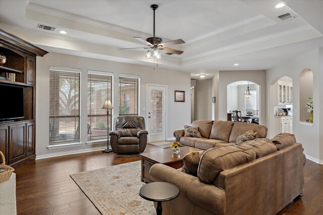 living room with visible vents, a raised ceiling, and dark wood finished floors