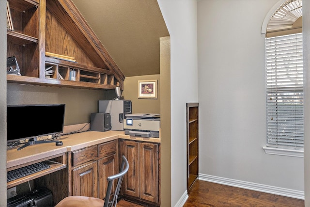 office area featuring dark wood-style floors, vaulted ceiling, built in study area, and baseboards